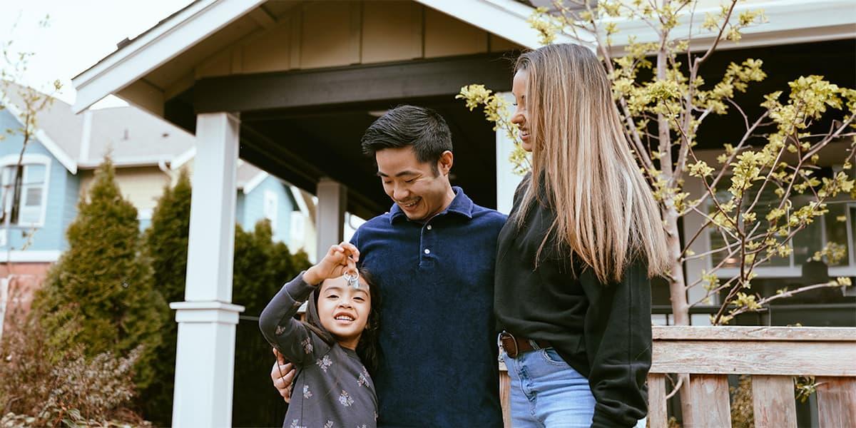 A family standing outside of their new home.